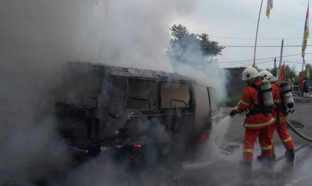 Petugas PMK berusaha memadamkan api yang membakar mobil Suzuki Carry di Surabaya