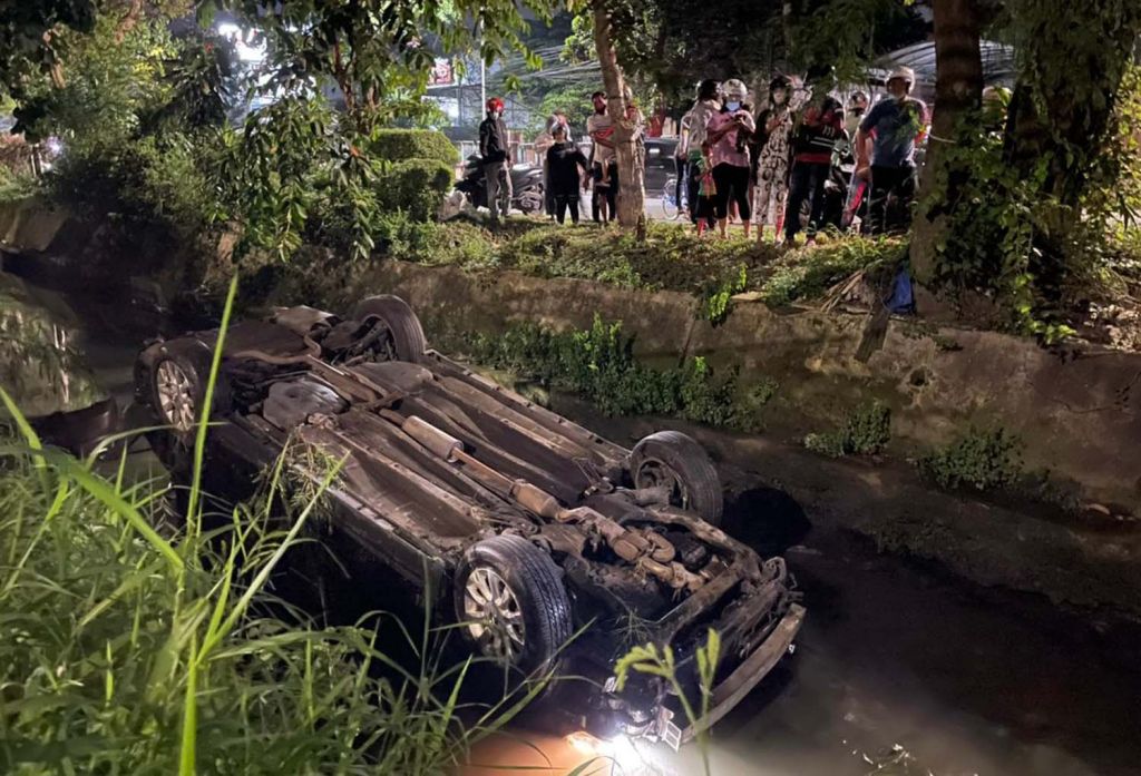 Mobil Nissan Teana terbalik di dalam sungai (Foto-foto: Dinas Pemadam Kebakaran Surabaya)