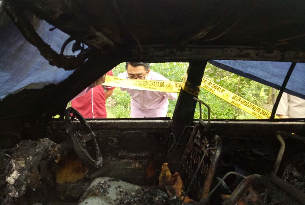 Petugas berusaha memadamkan api yang membakar mobil di Pasuruan