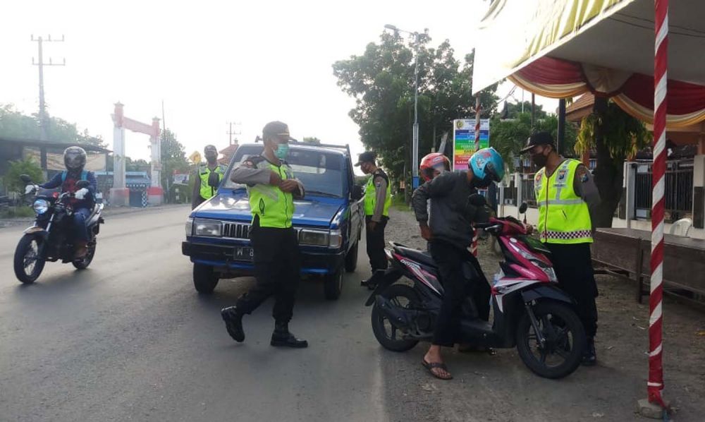 Sejumlah polisi di Mojokerto memeriksa identitas pengendara di salah satu titik penyekatan larangan mudik
