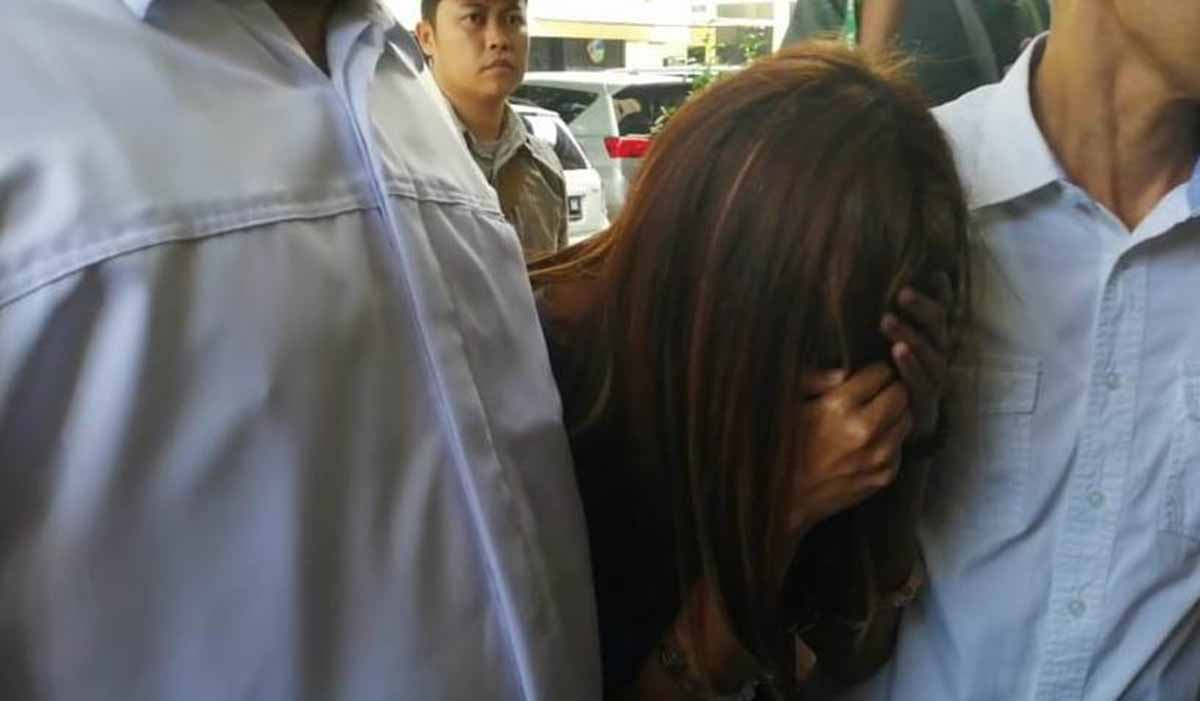 Mucikari ES saat digelandang penyidik di Polda Jatim