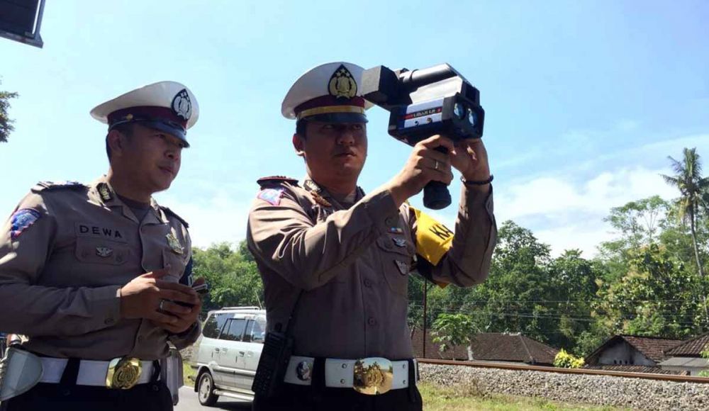 Kasatlantas Polres Blitar, AKP Muhammad Amirul Hakim menggunakan speed gun untuk mengontrol kecepatan kendaraan