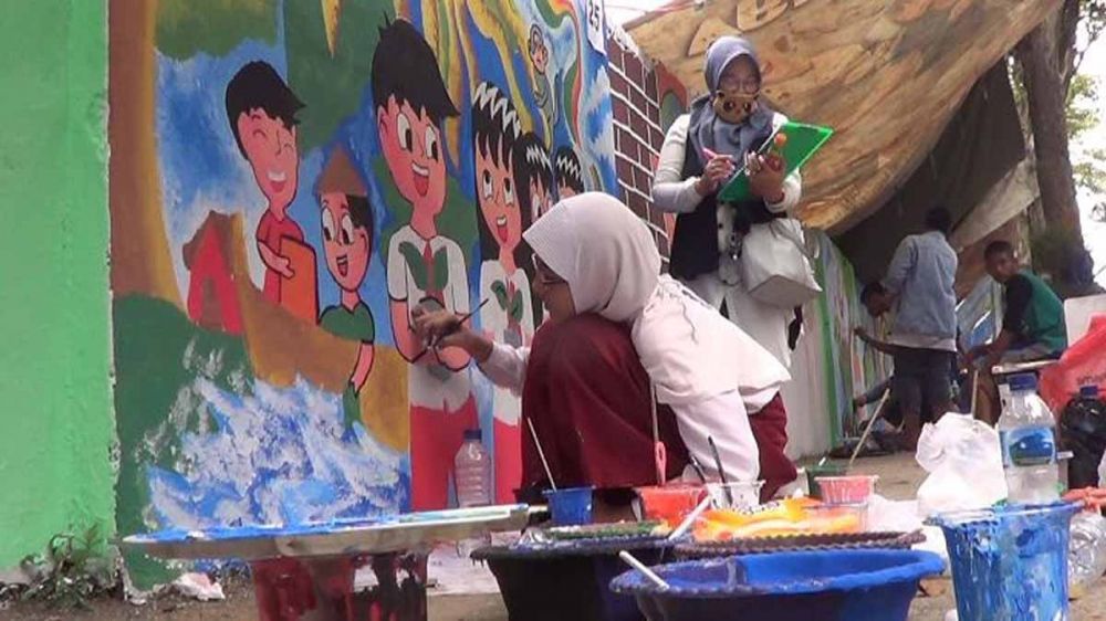 Salah satu pelajar melukis mural dalam rangka Hari Bumi di Mojokerto