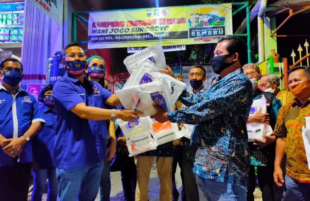 Ketua DPD Partai NasDem Surabaya Robert Simangunsong menyerahkan bantuan 21 paket APD kepada 7 Ketua RW Kampung Tangguh
