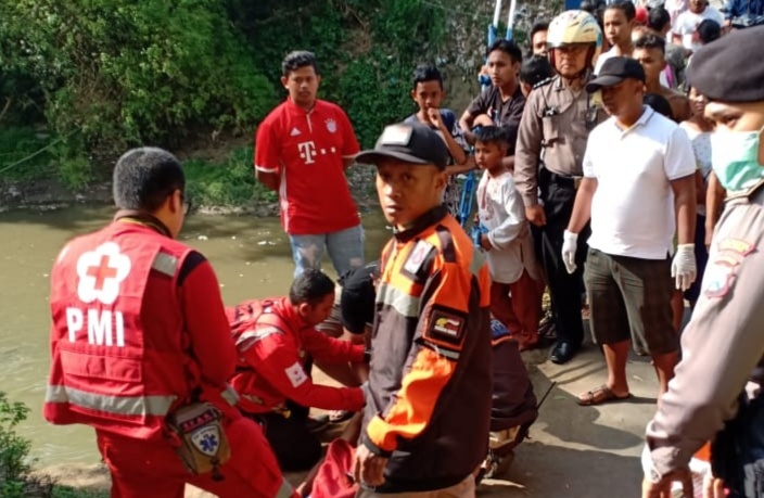 Petugas PMI mengevakuasi pria telanjang dada yang ditemukan pingsan di sungai.