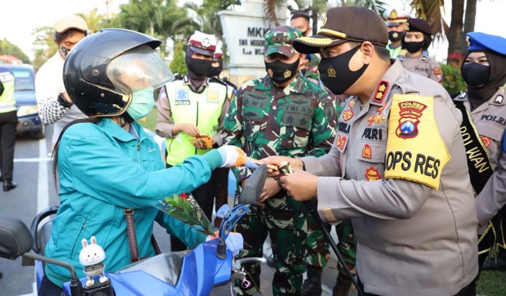 Kapolres Mojokerto AKBP Dony Alexander memberikan cokelat pada pengendara yang tertib