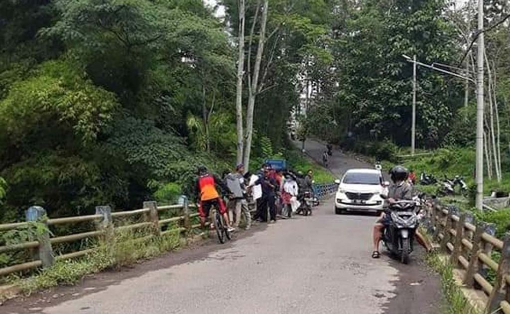 Warga melihat proses pencarian korban di Jembatan Dam Blobo, Kecamatan Kepanjen, Kabupaten Malang