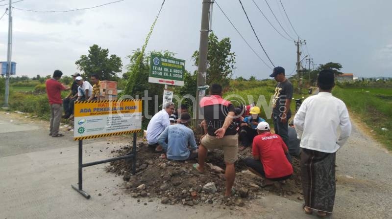 Anizar Firmadi Direktur Pelayanan PDAM Surya sembada bersama warga melihat proyek pemasangan pipa di kawasan Benowo/Foto: Fahrizal Tito