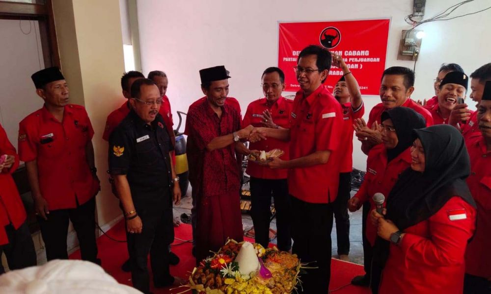 Ketua DPC PDIP Surabaya Adi Sutarwijono memberikan potongan tumpeng kepada Ketua PCNU Surabaya Muhibbin Zuhri