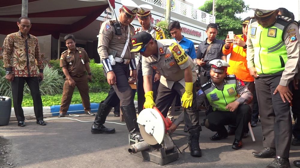 Pemusnahan knalpot brong dengan cara dipotong menggunakan gergaji mesin