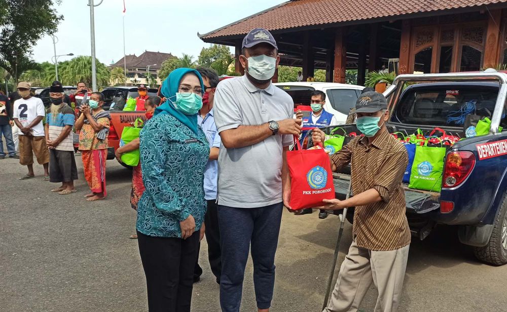 Ketua PKK Ponorogo Sri Wahyuni Ipong Muchlissoni bersama Bupati Ipong memberikan paket sembako kepada warga