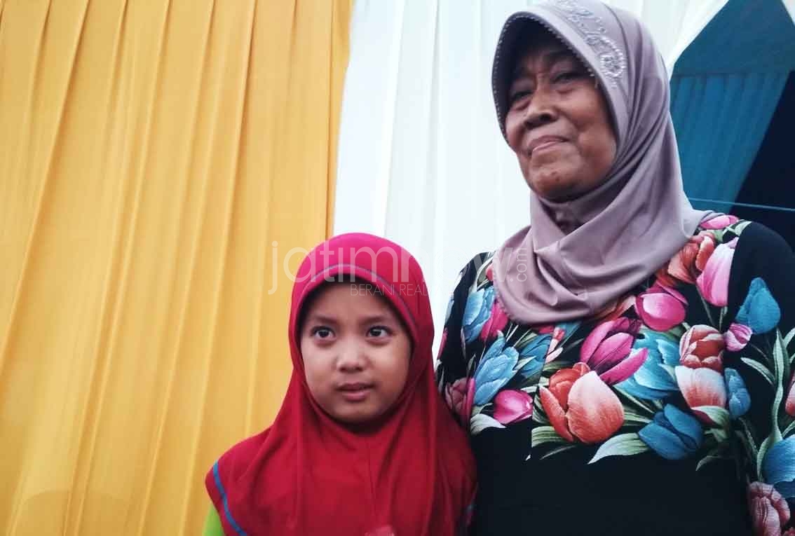 Aura Putri bersama neneknya saat menerima hadiah undian umrah
