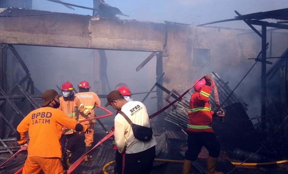 Petugas Pemadam Kebakaran berusaha memadamkan api yang membakar pabrik petis di Kota Pasuruan