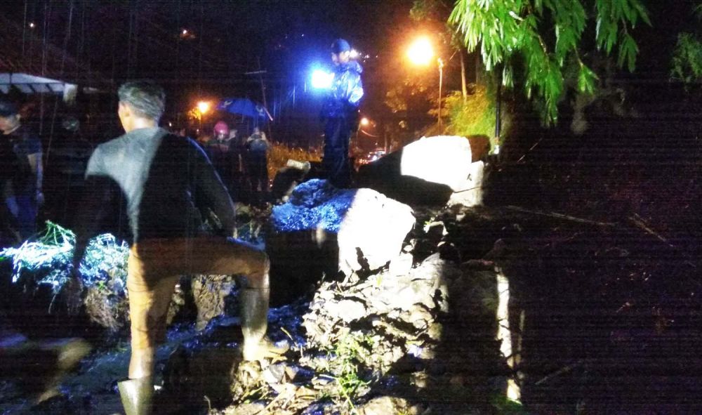 Petugas gabungan berupaya membersihkan material longsor di lokasi