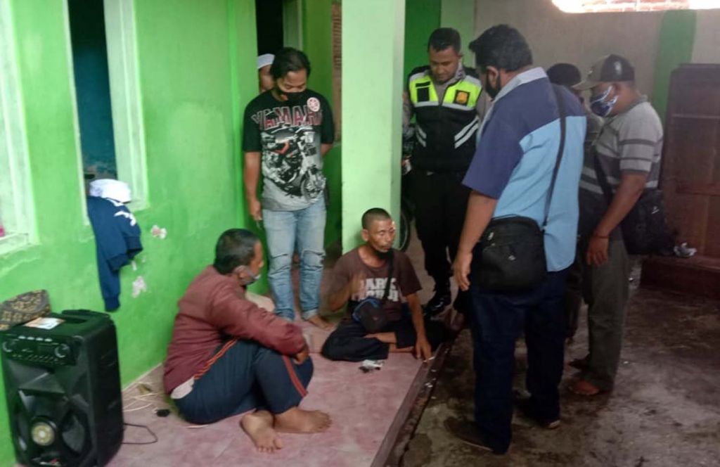 Paman (duduk kanan) yang membacok keponakan di Pasuruan saat diamankan polisi