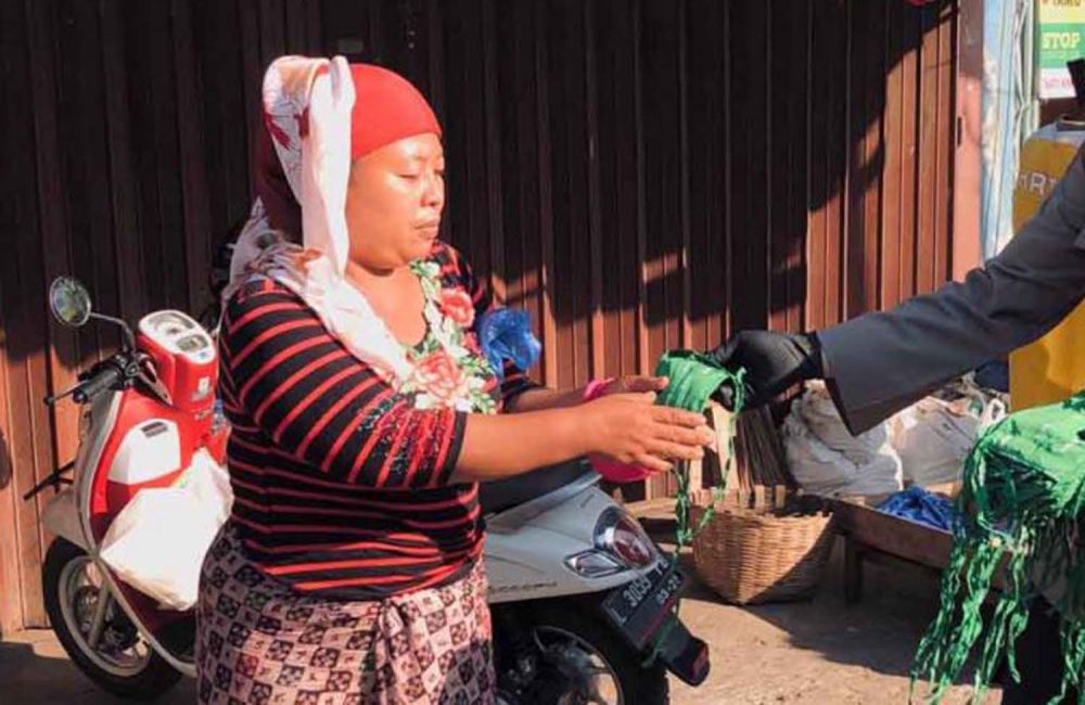 Seorang pedagang di Pasar Keputran Surabaya saat menerima pembagian masker gratis dari polisi pada Selasa (30/6/2020)