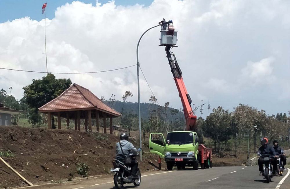 Petugas memasang PJU di salah satu jalan di Kota Batu