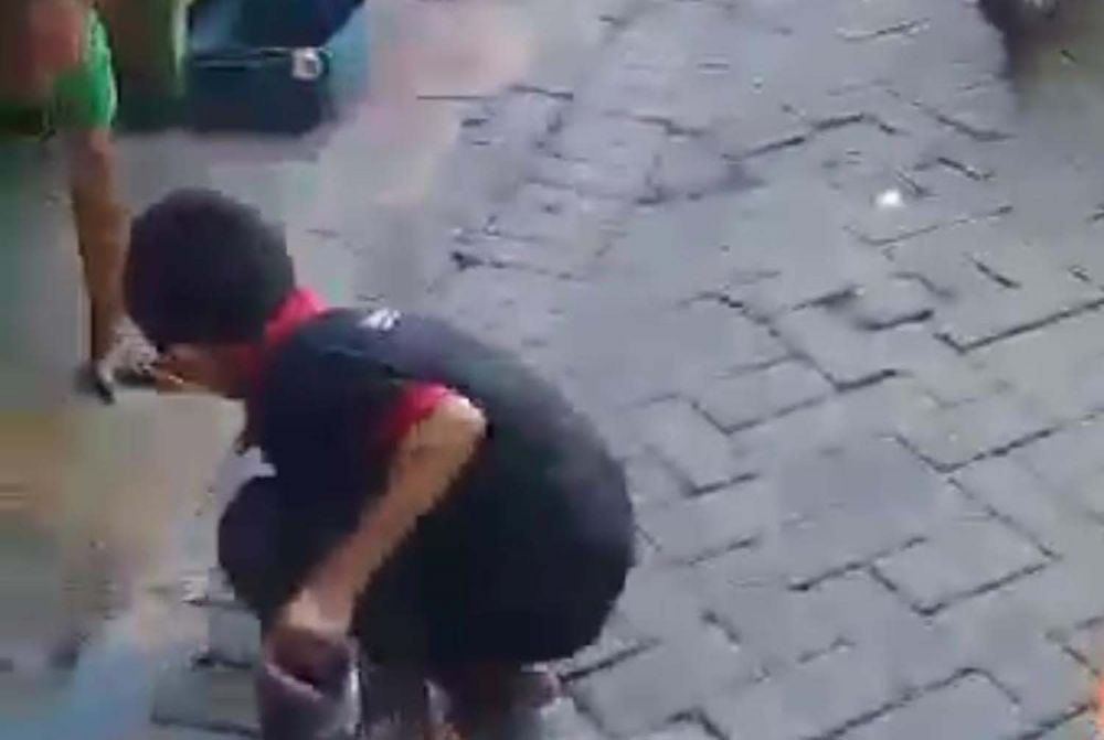 Seorang anak mengambil masker di atas jalan berpaving (Foto-foto: tangkapan layar video viral)