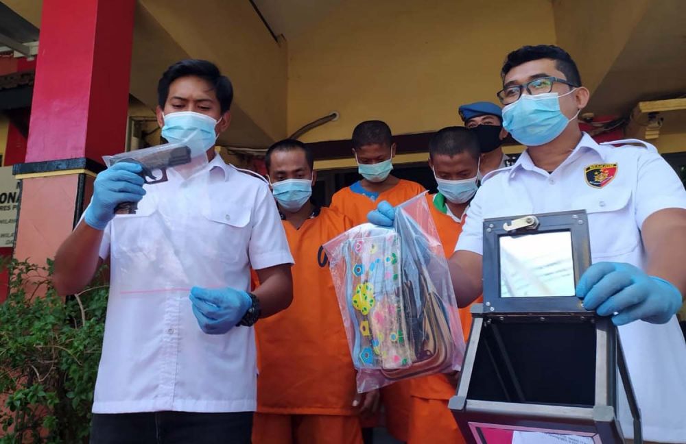 Kanit Reskrim Polsek Asemrowo Iptu Rizkika Atmadha (kiri) menunjukkan airsoft gun yang disita dari para pelaku