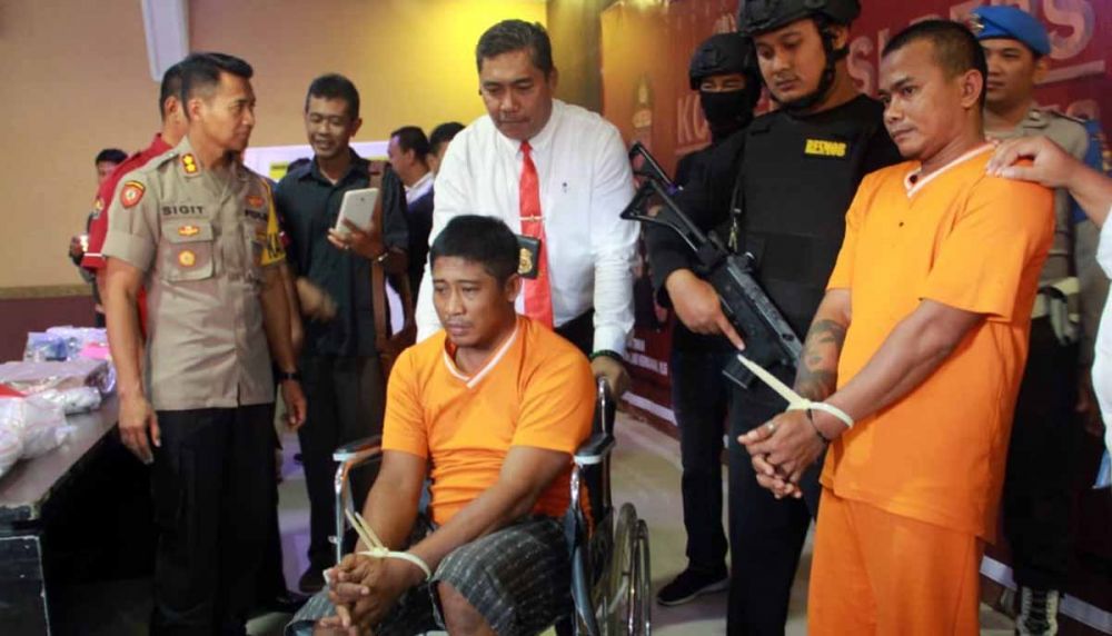 Kapolres Mojokerto Kota, AKBP Sigit Dany Setiyono (kiri) dan Kasatreskrim, AKP Ade Warokka (memegang kursi roda pelaku) 