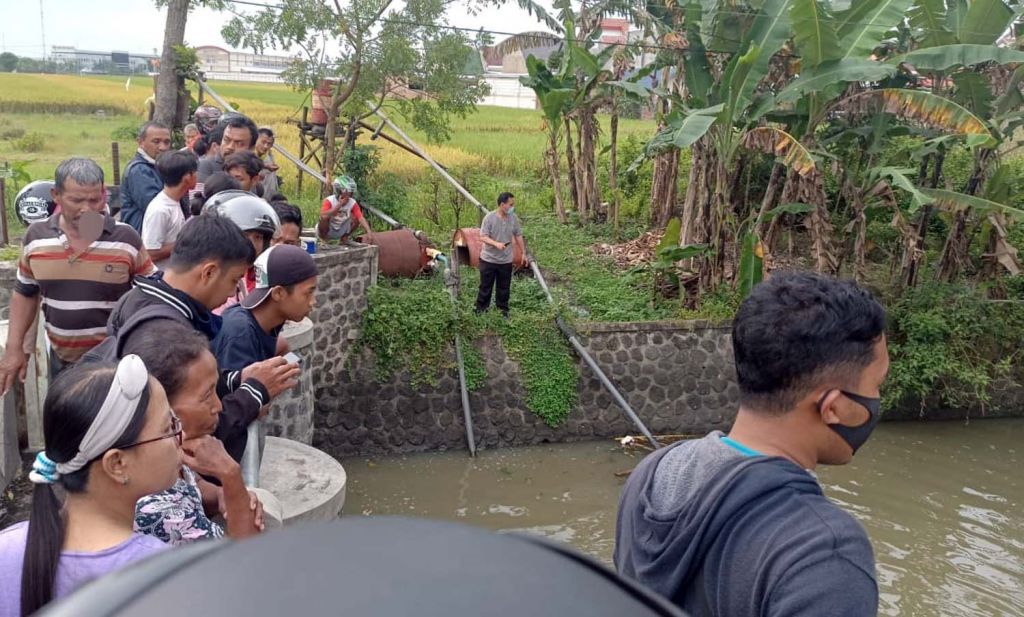 Warga melihat proses pencarian pelajar SD yang terpeleset ke sungai di Ngawi