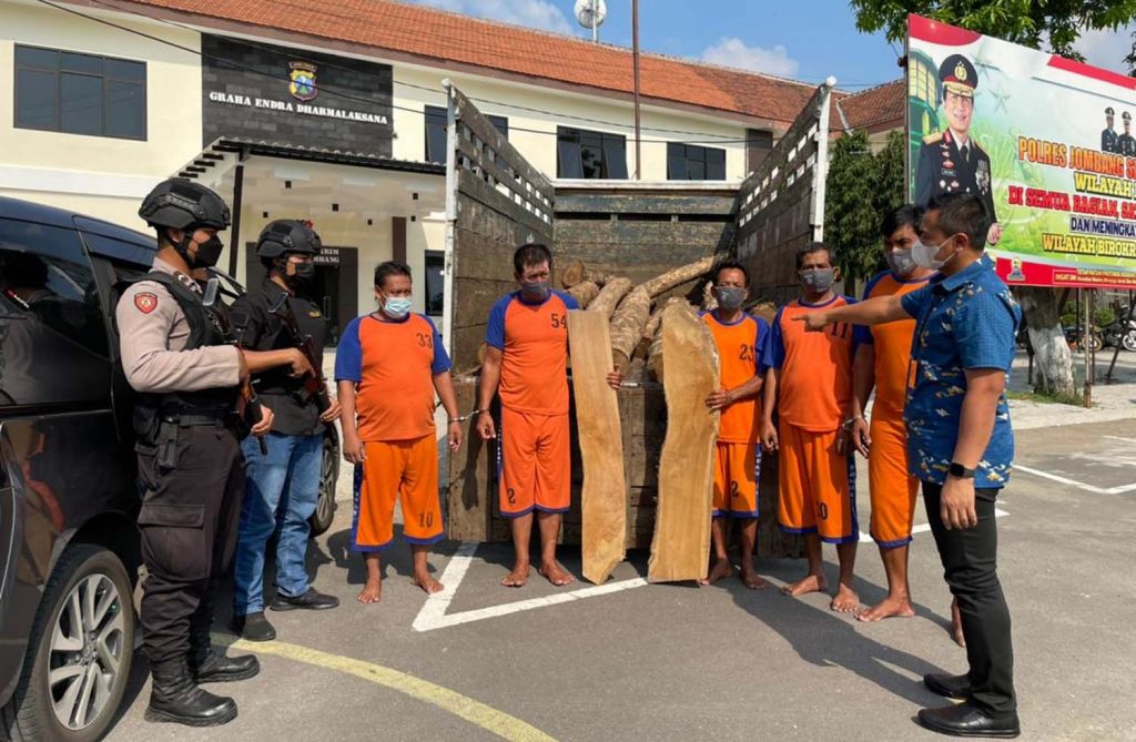 Kasatreskrim Polres Jombang, AKP Teguh Setiawan (kanan) menunjukkan kayu jati yang dicuri dan para tersangka