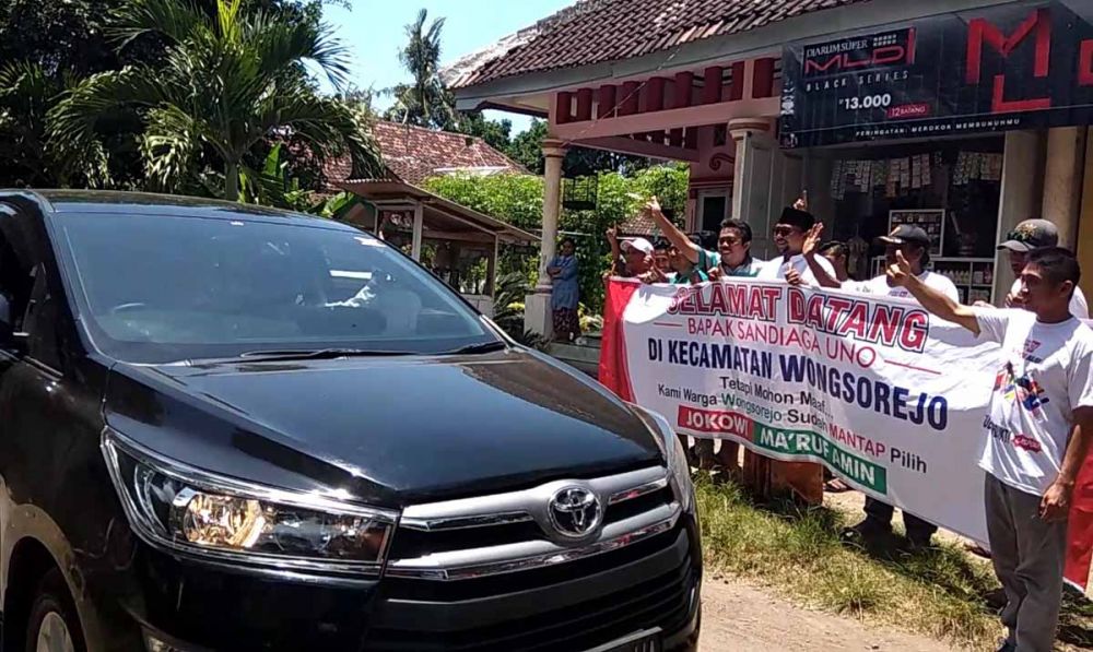 Sandiaga Uno melambaikan tangannya menyapa massa pendukung Jokowi yang menyambutnya di Banyuwangi