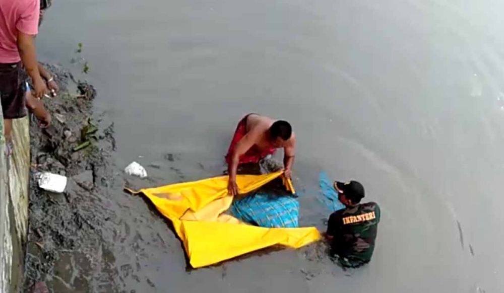 Petugas mengevakuasi jasad korban yang ditemuakan tewas mengambang di Sungai Gembong, Kota Pasuruan