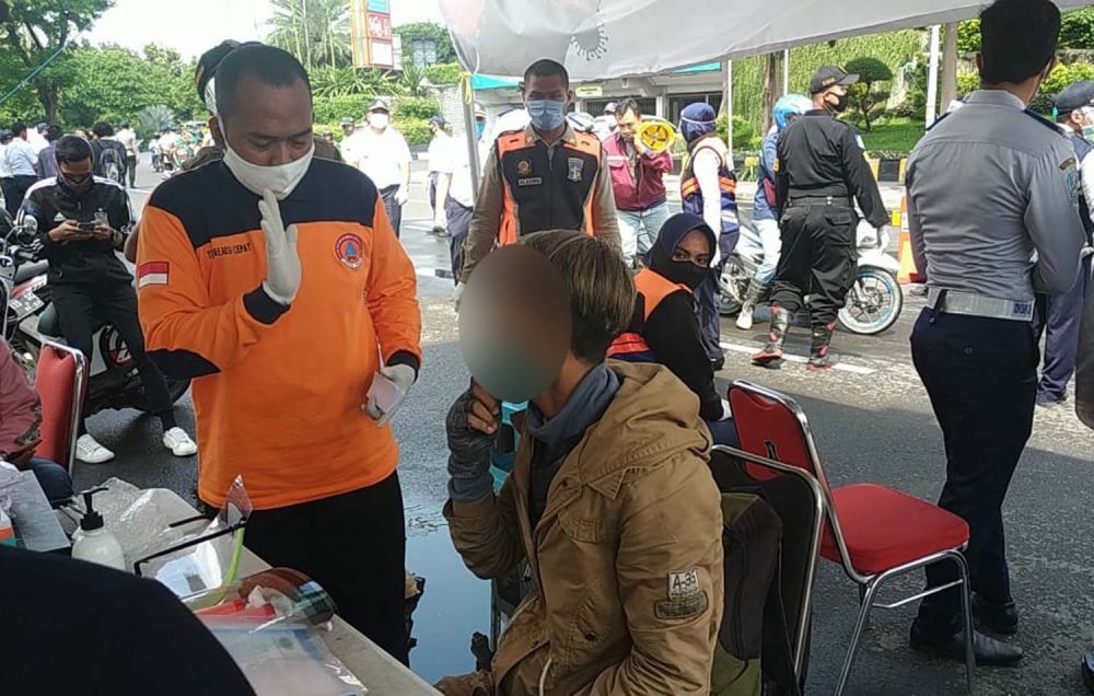 Pengendara motor berstatus ODP saat diperiksa petugas di Check Point PSBB Surabaya depan Cito (Foto: Istimewa)
