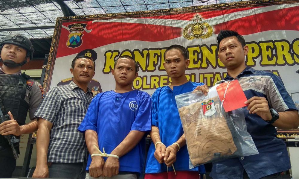 Kasatreskrim Polres Blitar Kota AKP Ardhi Purboyo menunjukkan barang bukti dan dua pelaku pengeroyokan