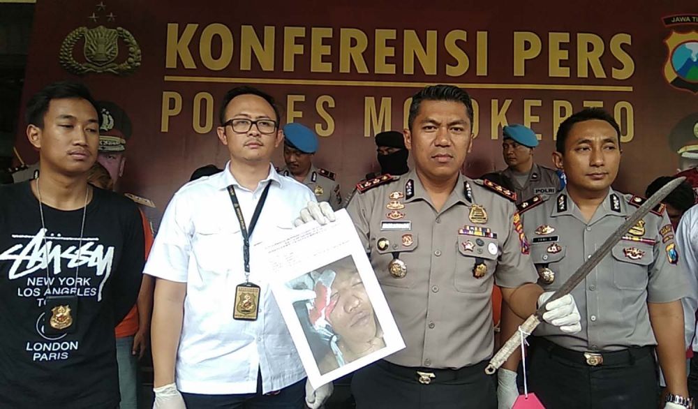Kapolres Mojokerto AKBP Feby Hutagalung menunjukkan foto korban dan senjata tajam yang dipakai salah satu pelaku pengeroyokan