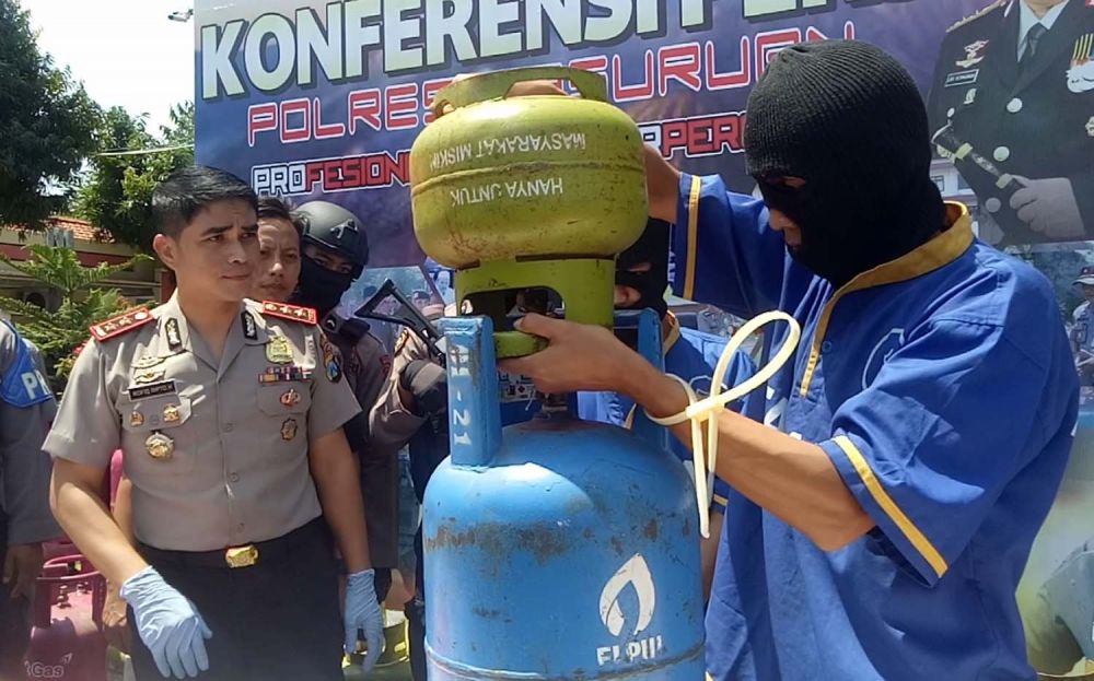 Kedua tersangka mempraktikkan cara pengoplosan elpiji di depan Kapolres Pasuruan AKBP Rofiq Ripto Himawan