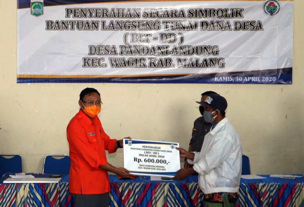 Kadis PMD Jatim Moh. Yasin memberikan  BLT DD secara simbolis kepada warga di Balai Desa Pandanlandung, Kec. Wagir, Kab. Malang, Kamis (30/4/2020)