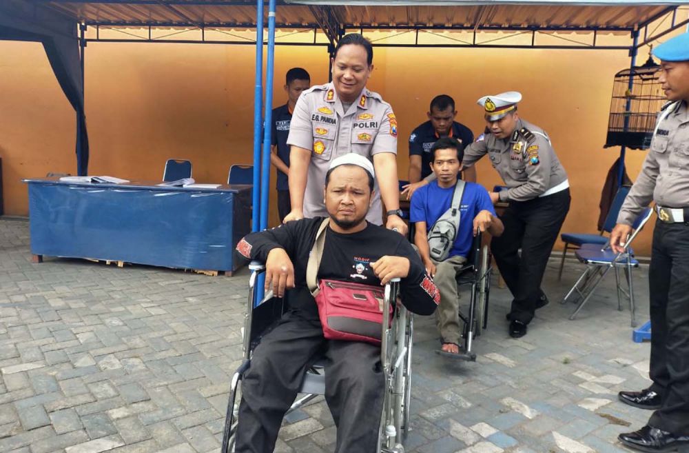Kapolres Tulungagung AKBP Eva Guna Pandia membantu seorang penyandang disabilitas saat melakukan ujian permohonan SIM