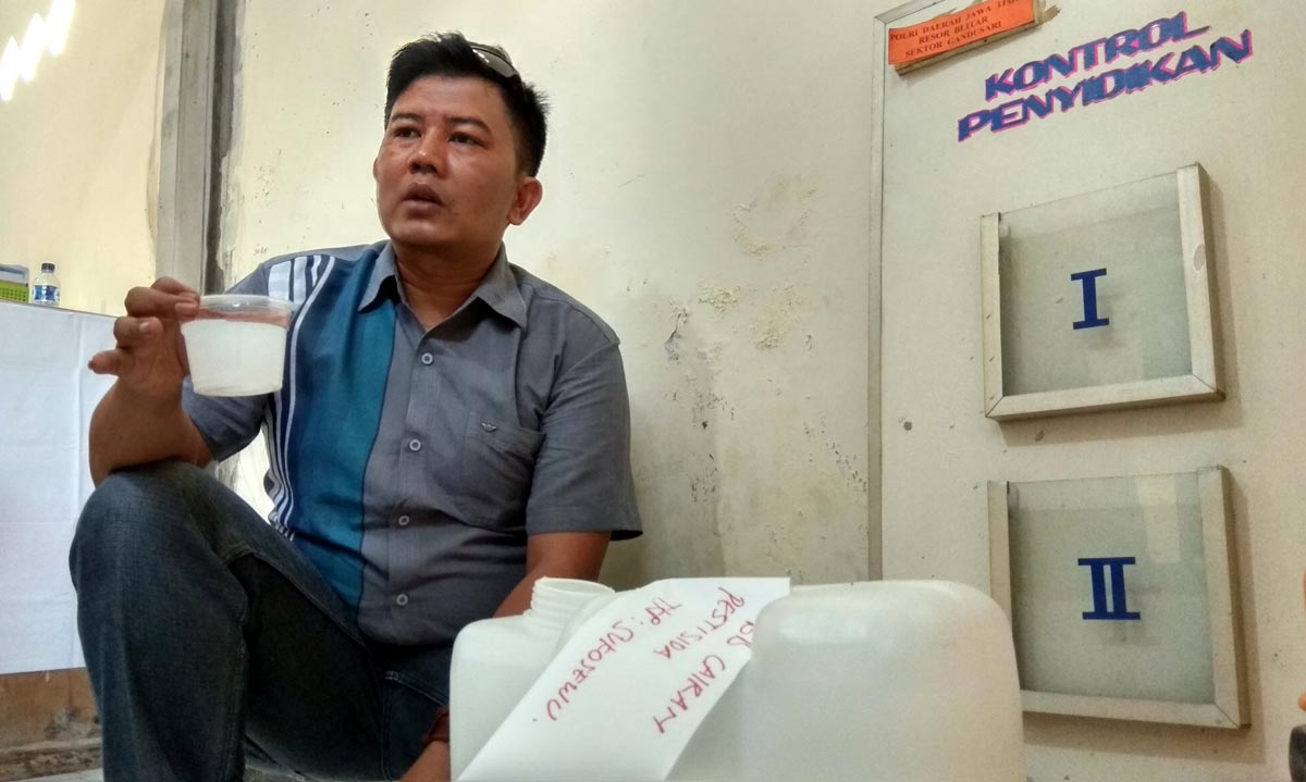 Petugas menunjukkan barang bukti air campur pestisida.