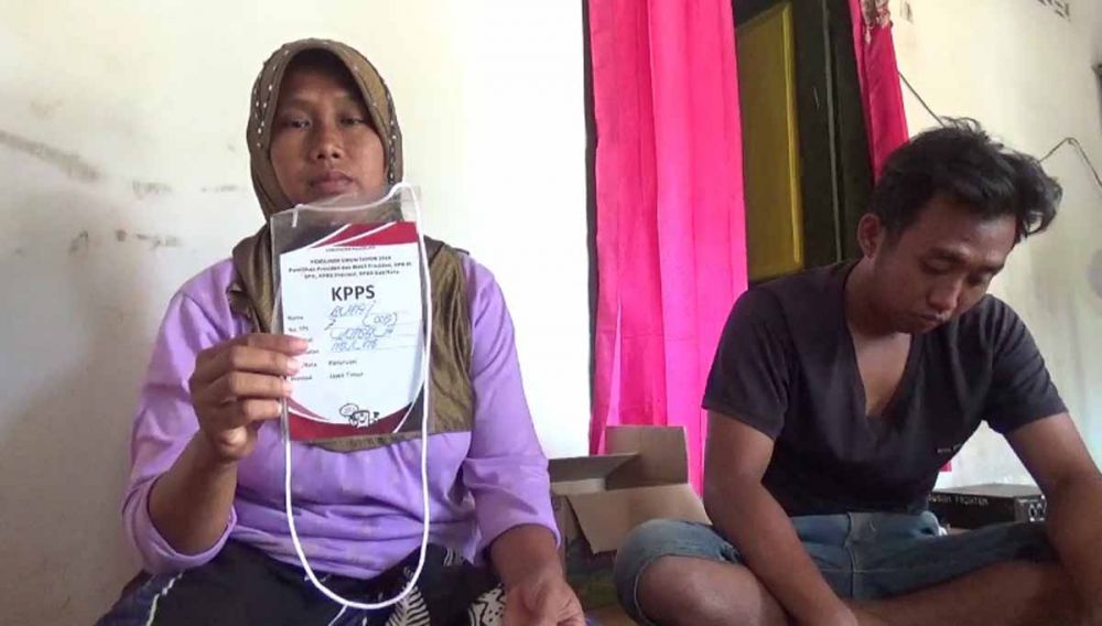 Sri Wahyuni, istri Busa'i menunjukkan kartu KPPS milik suaminya