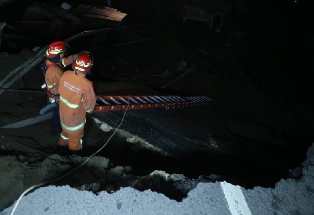Foto Istimewa. Petugas menggali lubang jalan Raya Gubeng yang ambles untuk mencari korban.