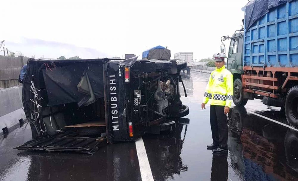 Anggota PJR Polda Jatim mengamankan lokasi pikap terbalik di Jalan Tol Gresik-Tandes