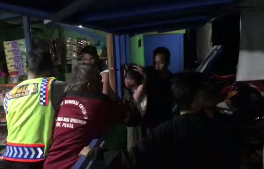 Anggota Bhabinkamtibmas Polsek Pagak, Polres Malang mencoba meredam emosi warga yang memukuli polisi gadungan