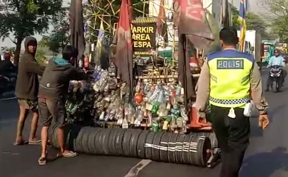 Anggota Unit Lantas Polsek Beji menggiring Vespa rongsok yang ditumpangi 6 anak punk ke pos lantas