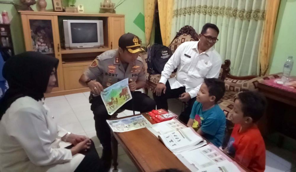 Kapolres Pasuruan Kota AKBP Dony Alexander saat memberikan modul untuk panduan para siswa belajar di rumah