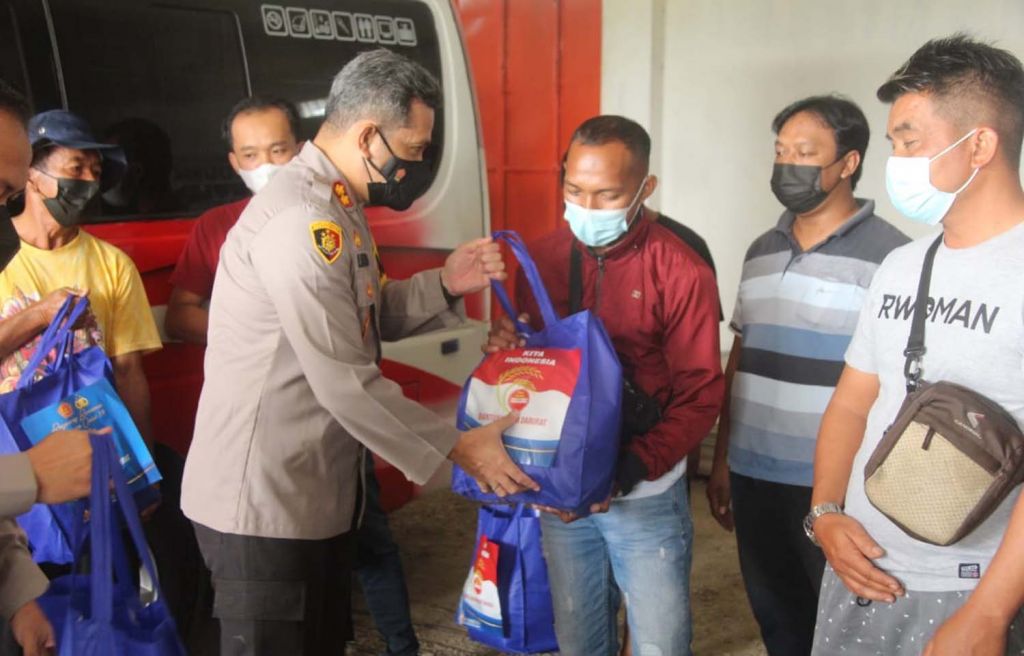 Kapolres Blitar AKBP Leonard Sinambela saat memberikan bantuan paket sembako pada para sopir bus dan travel