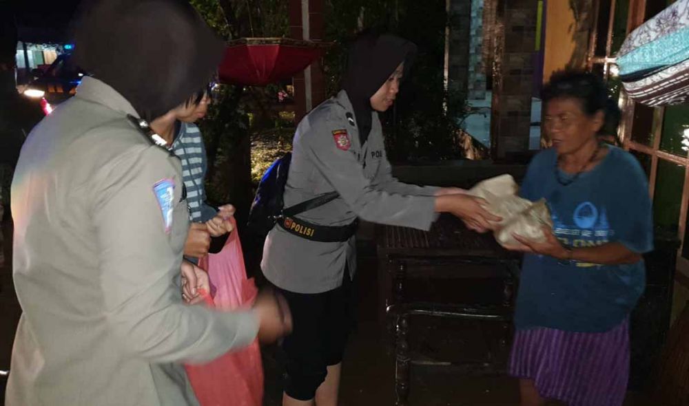 Para polwan dari Srikandi Bhayangkara Polres Trenggalek membagikan makanan ke korban banjir