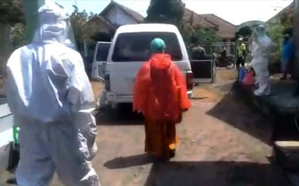 Petugas mengevakuasi seorang perempuan di Jombang yang terkonfirmasi positif Corona