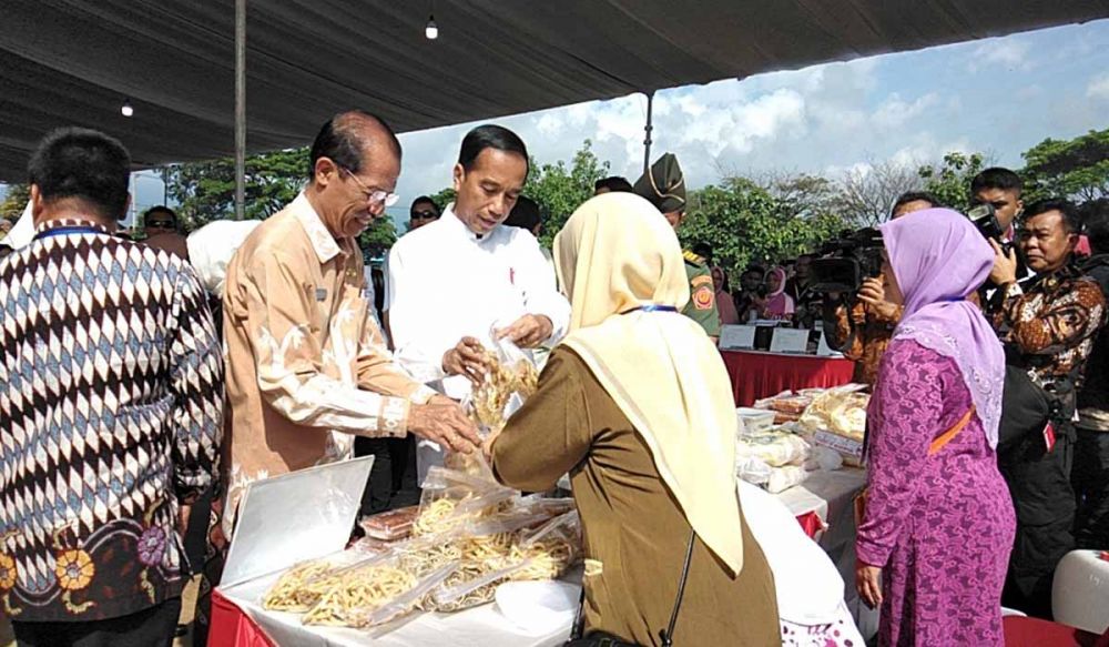 Presiden Jokowi saat melihat barang yang dijual nasabah Mekaar PNM di Magetan