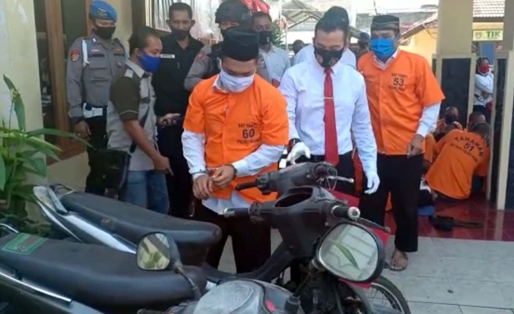 Pria bertongkat (berdiri kanan) yang mencuri motor 10 kali diamankan di Mapolres Ngawi