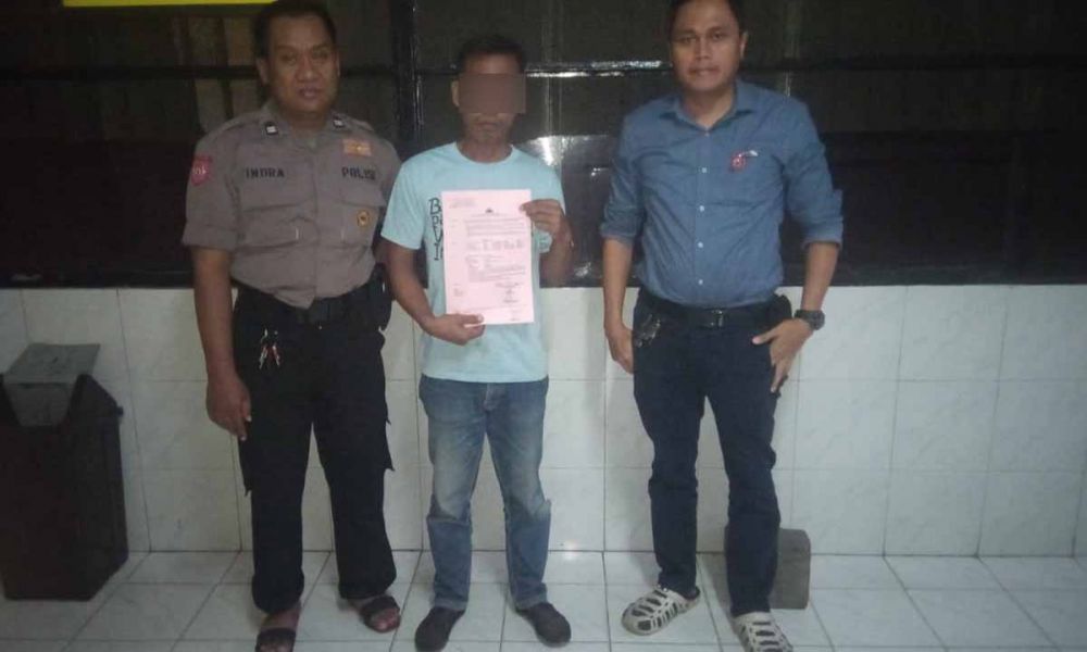 SH (tengah), ayah yang cabuli anak tirinya saat diamankan di Mapolrestabes Surabaya