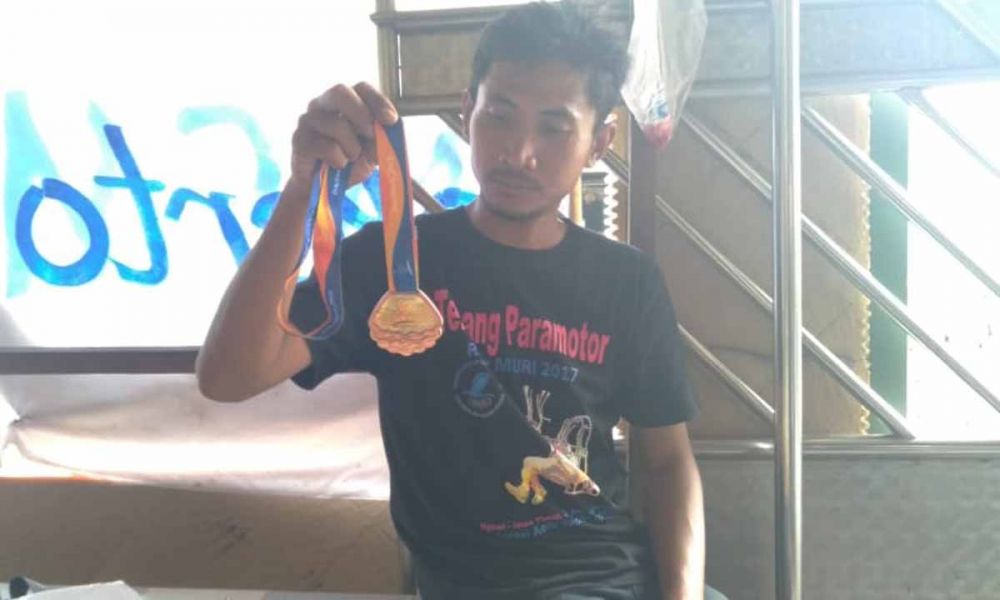 Mukhammad Akbar atau Ilung saat menunjukkan salah satu medali yang diraihnya karena keahliannya terbang (foto-foto: Achmad Supriyadi/jatimnow.com)