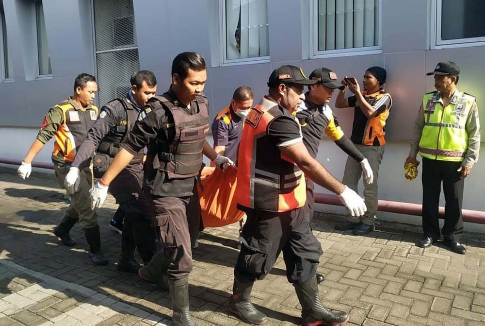 Petugas mengevakuasi jasad pria yang diduga loncat dari lantai 4 gedung di Surabaya (Foto: Istimewa)