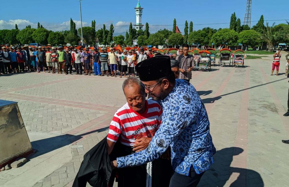 Bupati Ipong juga memberikan baju khas Ponorogo kepada para pengayuh becak wisata